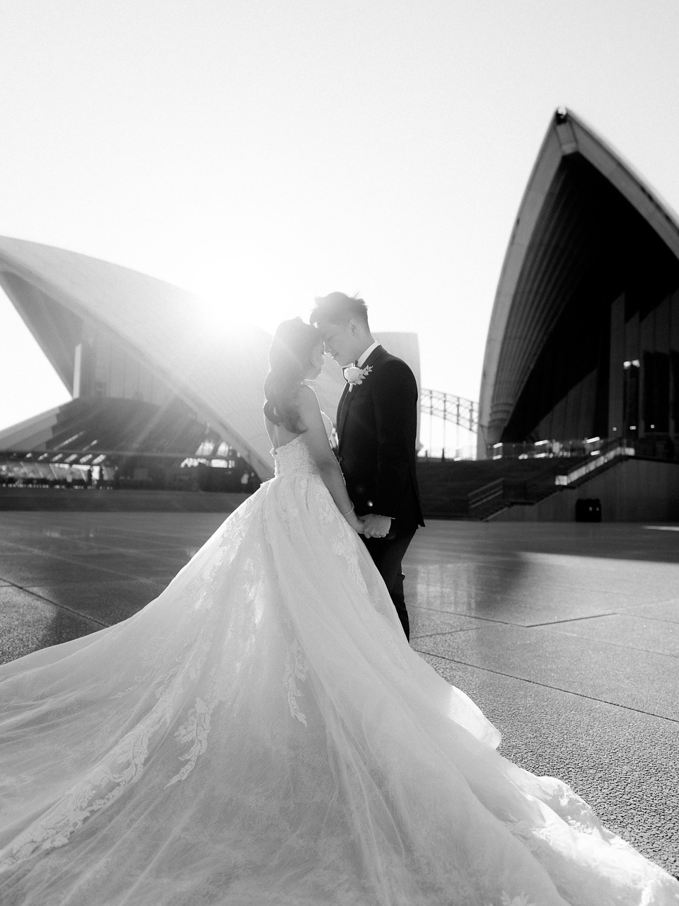 bride and groom standing in front of sydney opera house